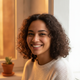 Close-up portrait of a smiling woman with diverse features, conveying happiness and trust. Her expression is genuine and sati
